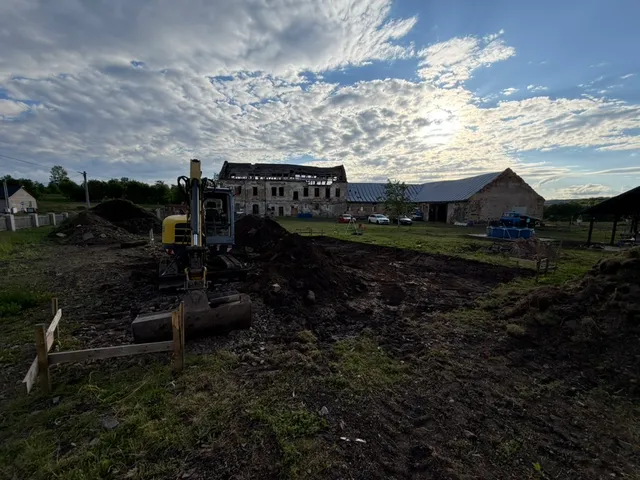 Skutečná skrývka začíná. Bagr, vyznačený obrys a hromady zeminy před zámečkem.