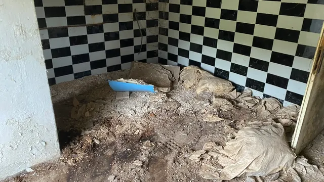 Šachovnicový obklad pod nánosem suti — jedna z prvních místností, do kterých jsme se dostali.