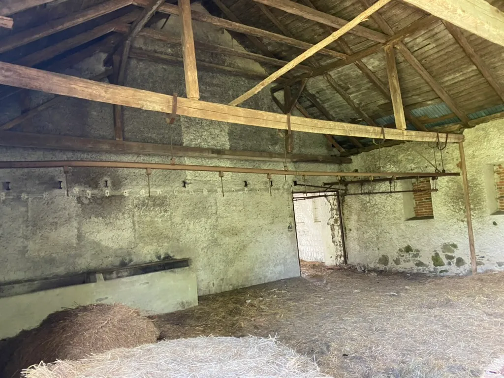 Betonový žlab a řada úvazů podél zdi — stodola dřív sloužila jako stáj.