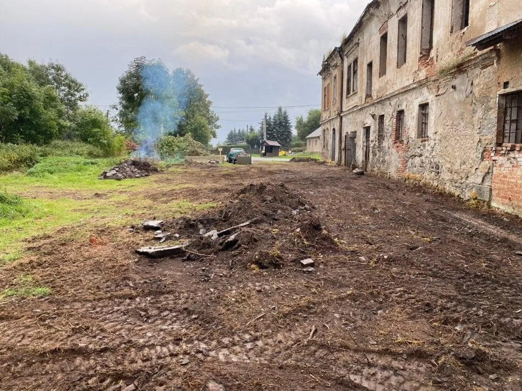 Vytrhané kořeny, hromada k odvozu a dým z pálení náletů.