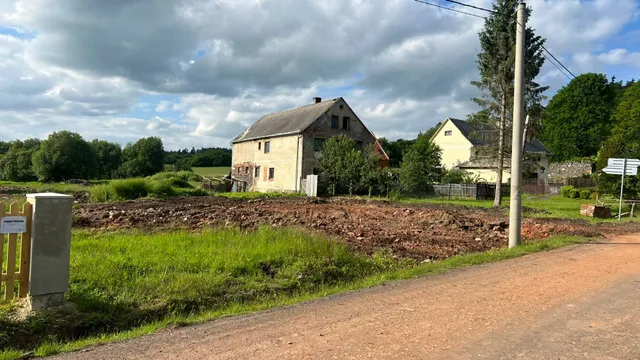 Kde stál dům se stodolou, je jen hromada suti. Za ní stojí náš zámeček; u plotu už visí cedule s povolením.