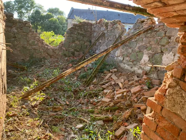 Pohled zevnitř ruiny. Přes zbořenou stěnu vykukuje náš statek — soused přes dvůr.