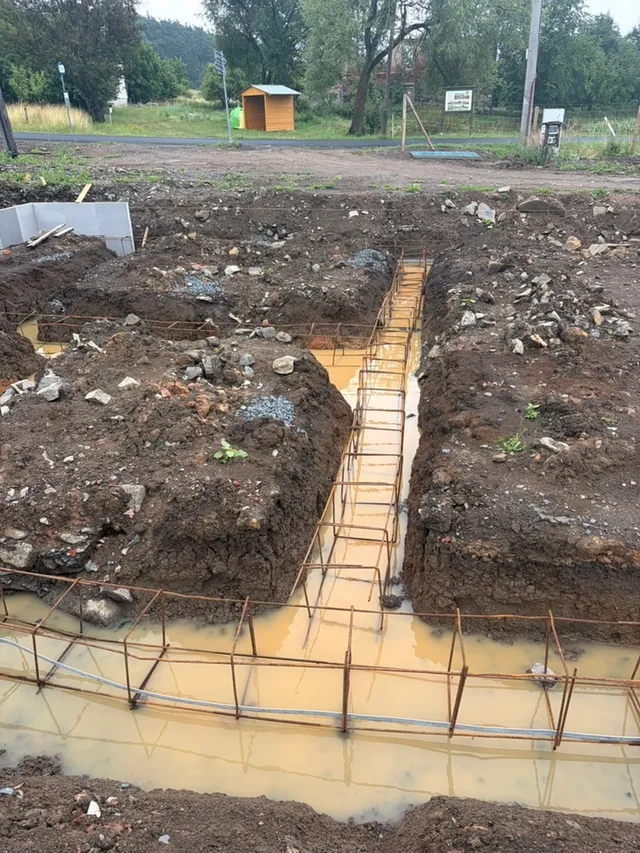 XPS vymezuje část pásu, za ním zůstává širší výkop; uvnitř leží výztuž.
