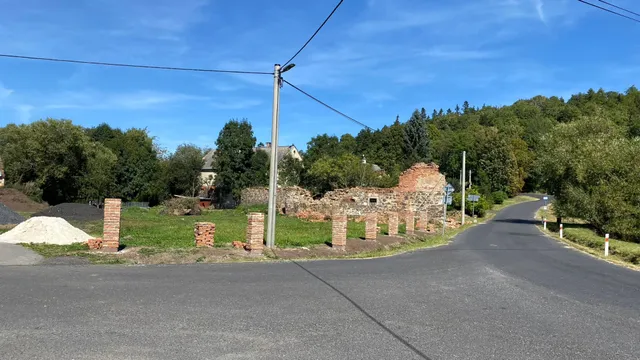 Sloupky pokračují podél silnice až k ruině. Hranice pozemku je čím dál čitelnější.