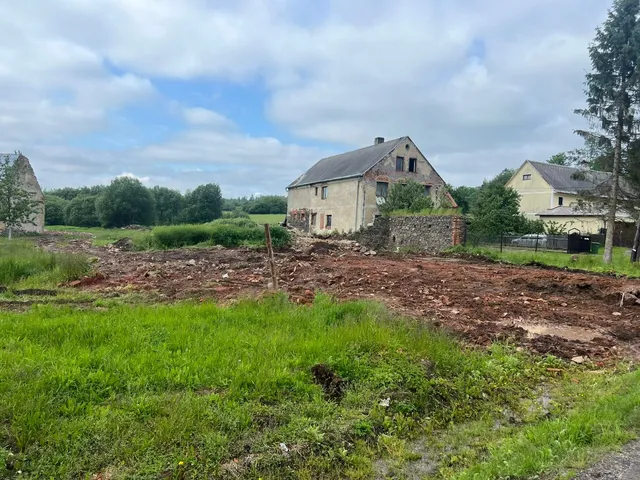 Rozvaliny po demolici. Vlevo v dálce prosvítá zeď další staré ruiny, vpravo obytná část statku.