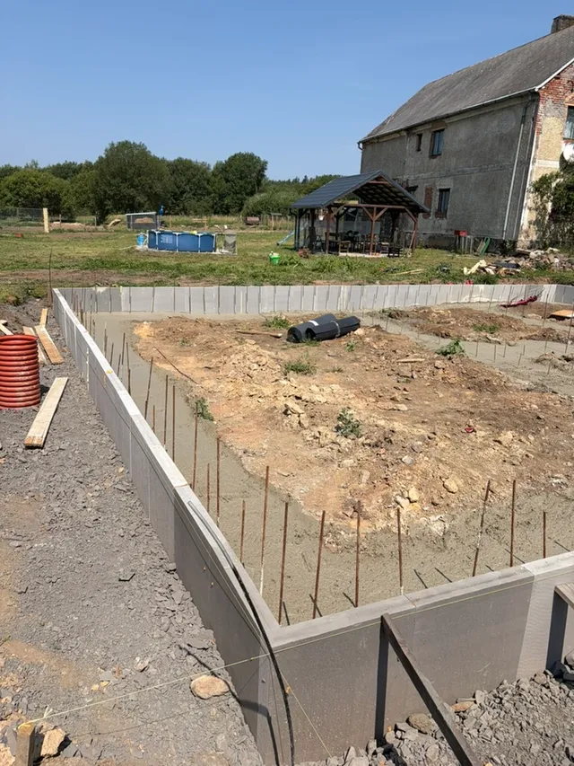Detail pásů po betonáži: XPS drží linii, nad betonem vyčnívá výztuž.