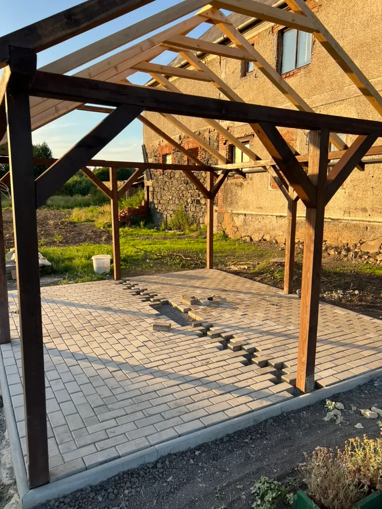 Vzor dlažby se skládá kus po kuse. Každý zub a kříž znamená další řezání — nejnáročnější část celé pergoly.