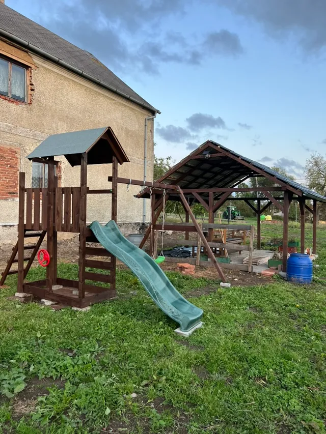 Vedle pergoly přibylo dětské hřiště se skluzavkou — pro návštěvy s dětmi. Levná koupě, velká radost.